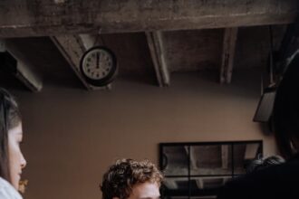 Photo of a Man with Curly Hair Holding a Glass of Beer