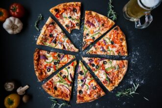 table garnie de différentes pizzas et accompagnements pour une soirée conviviale