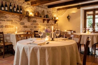 Table romantique dressée pour deux dans un restaurant traditionnel d'Occitanie, avec décor en pierre et ambiance chaleureuse à la bougie