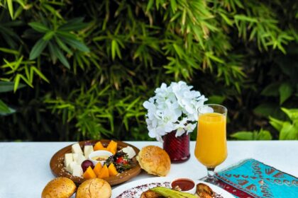 bread with vegetable on white ceramic plate beside drinking glass with yellow liquid